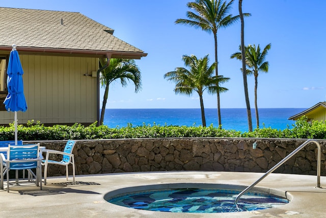 view of swimming pool with a patio, a water view, and an in ground hot tub