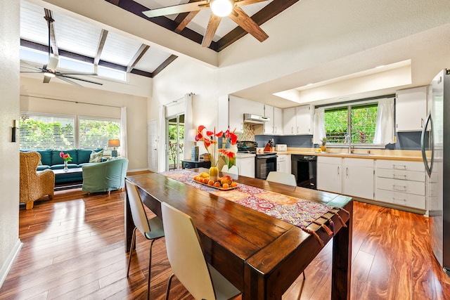 kitchen with vaulted ceiling with beams, white cabinetry, a wealth of natural light, and electric range oven