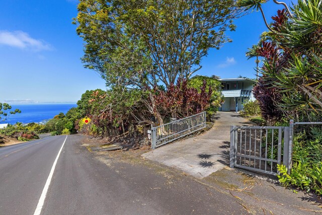 view of street with a gate and a water view