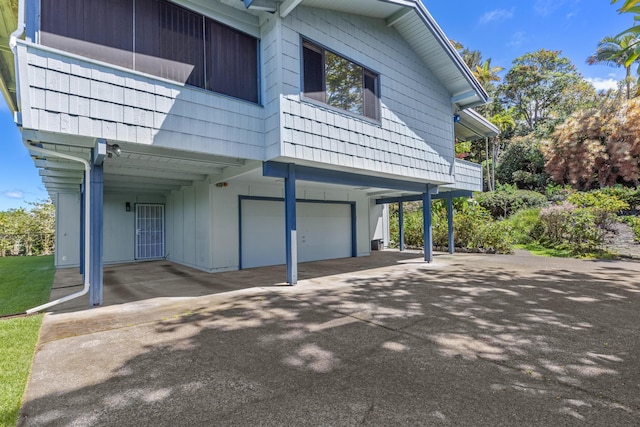 view of side of property with a carport and an attached garage