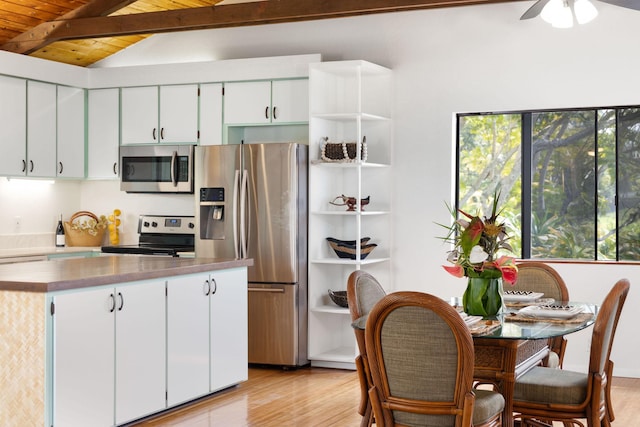 kitchen featuring lofted ceiling with beams, appliances with stainless steel finishes, light wood finished floors, and plenty of natural light