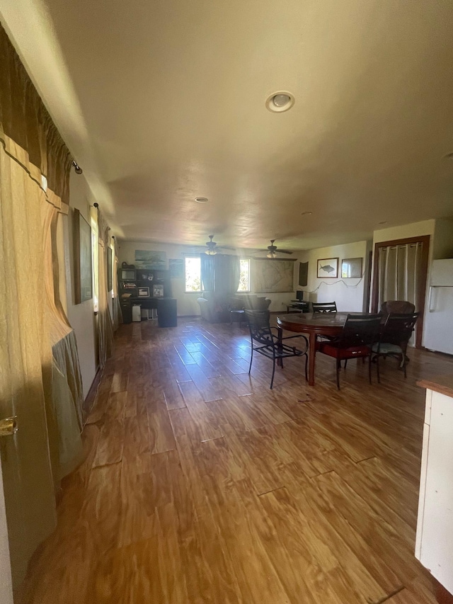 dining space with a ceiling fan and wood finished floors