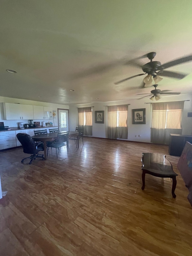 unfurnished living room with wood finished floors and a ceiling fan