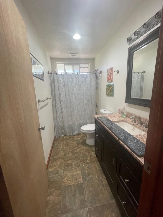 full bath featuring curtained shower, visible vents, toilet, vanity, and baseboards