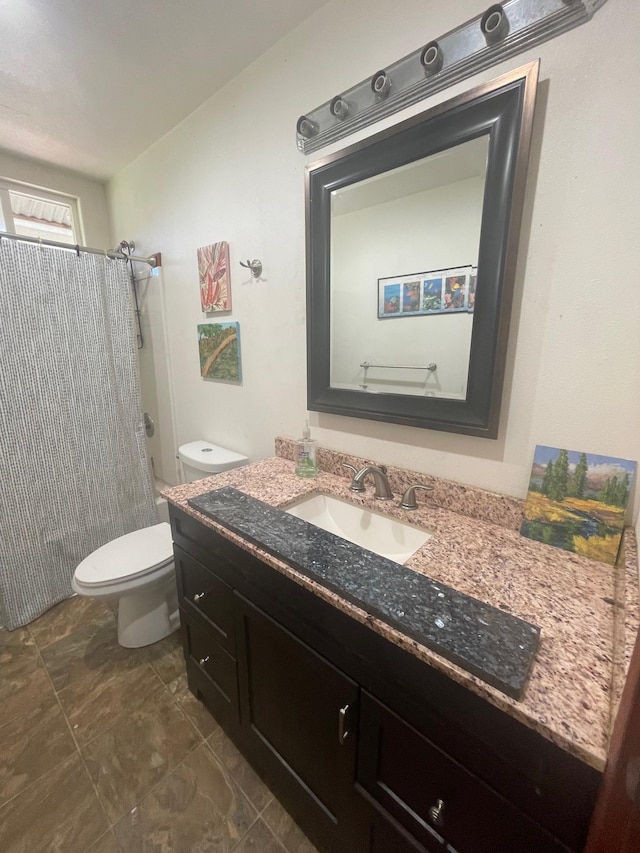 full bathroom featuring a shower with shower curtain, vanity, and toilet