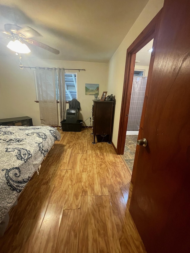 bedroom featuring a ceiling fan, baseboards, and wood finished floors