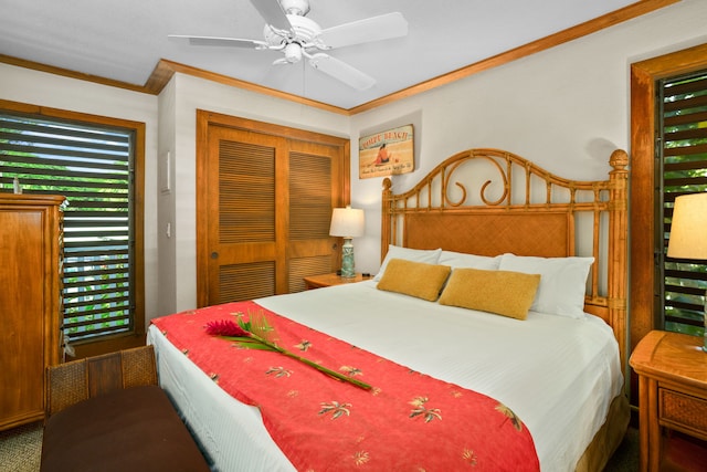 carpeted bedroom with a closet, ceiling fan, and crown molding