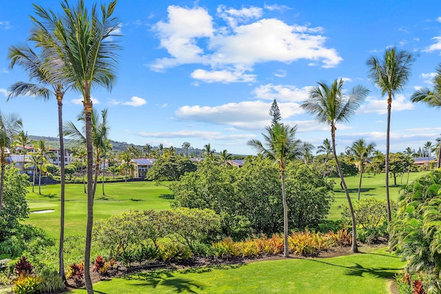 view of property's community featuring view of golf course and a lawn