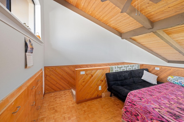 bedroom with vaulted ceiling with beams, wood walls, wainscoting, and wood ceiling