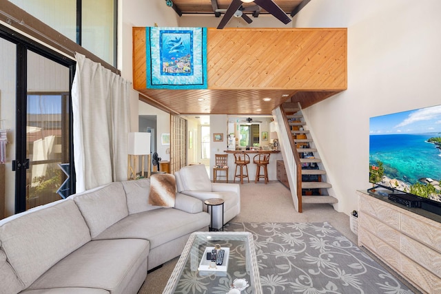 living area with carpet floors, wooden ceiling, stairs, and a ceiling fan