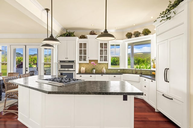 kitchen with pendant lighting, french doors, dark hardwood / wood-style floors, a kitchen island, and a kitchen bar