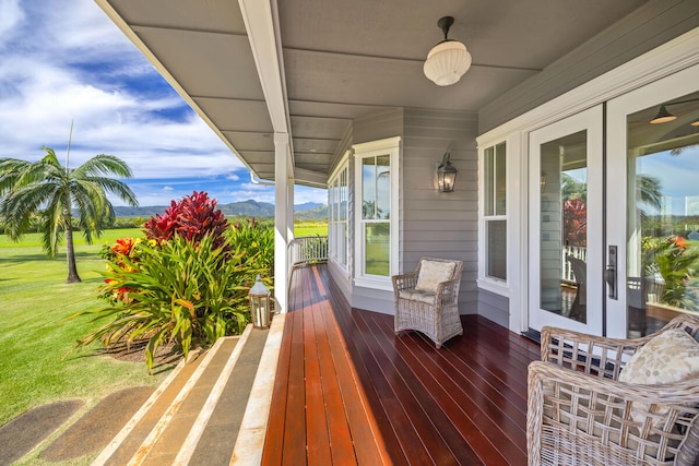 wooden deck featuring ceiling fan and a yard