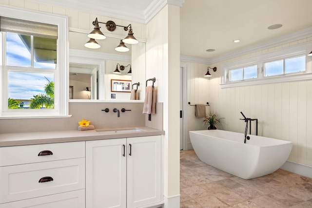 bathroom featuring plenty of natural light, a bathtub, and ornamental molding