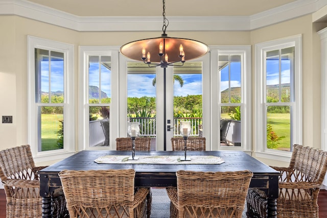 sunroom / solarium featuring a healthy amount of sunlight and a chandelier