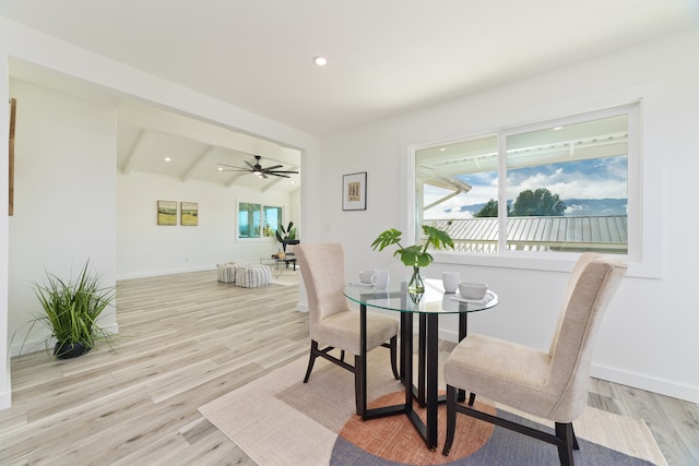 dining space with light hardwood / wood-style floors, vaulted ceiling with beams, and ceiling fan