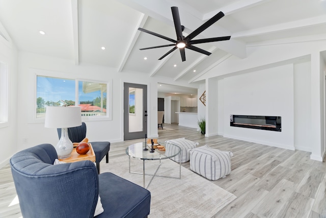 living room featuring ceiling fan, vaulted ceiling with beams, and light hardwood / wood-style floors