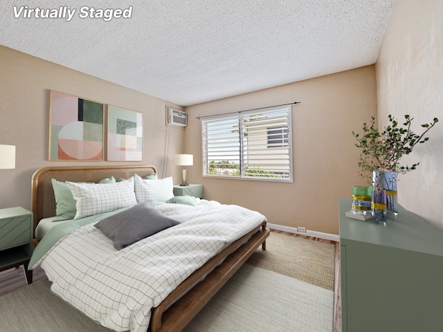 bedroom featuring carpet flooring, a wall mounted air conditioner, and a textured ceiling