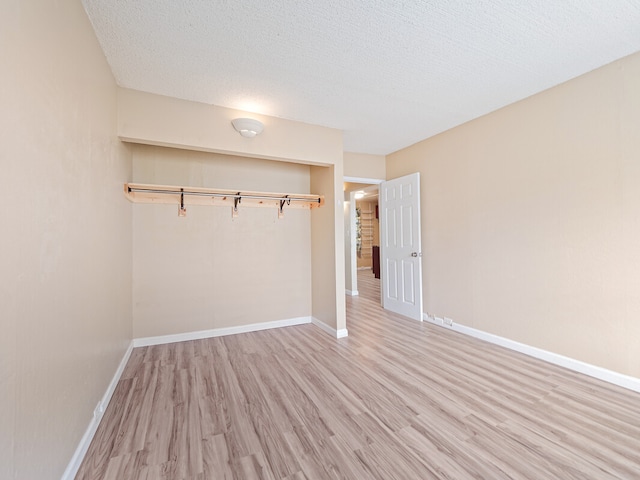 unfurnished bedroom with a textured ceiling, a closet, and hardwood / wood-style flooring