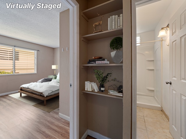 bedroom featuring light wood-type flooring and a textured ceiling