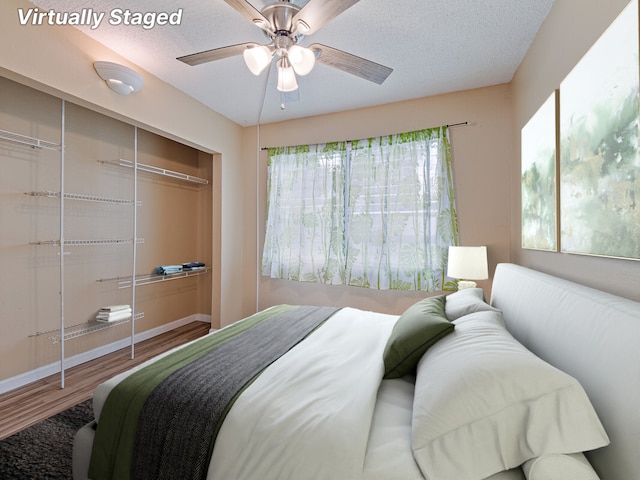 bedroom with ceiling fan, a closet, wood-type flooring, and multiple windows