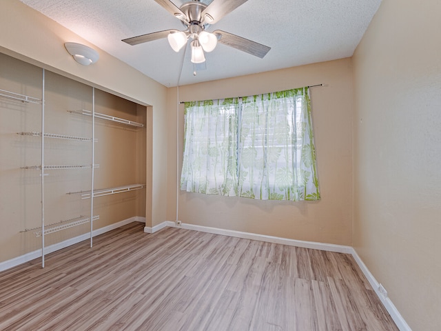 unfurnished bedroom featuring a closet, a textured ceiling, ceiling fan, and light hardwood / wood-style floors