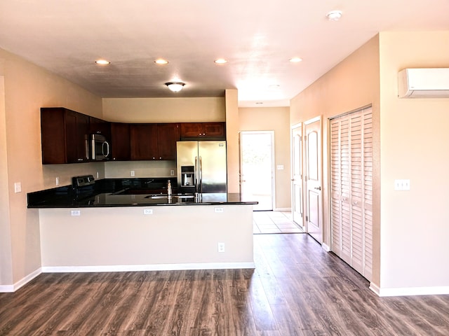 kitchen with kitchen peninsula, stainless steel appliances, hardwood / wood-style flooring, and dark brown cabinetry