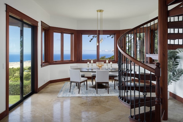 dining room featuring a water view, an inviting chandelier, and a healthy amount of sunlight