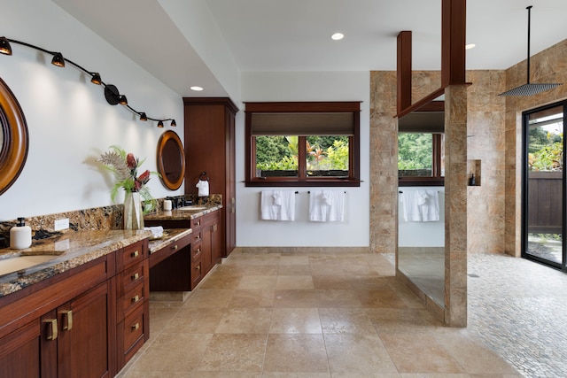 bathroom with walk in shower, vanity, and tile walls