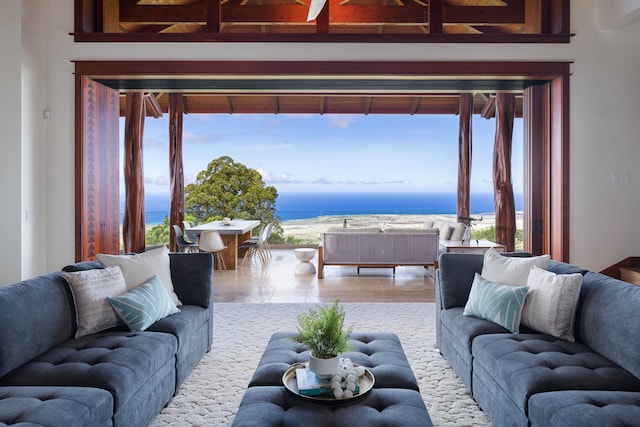 living room with beam ceiling, a water view, and hardwood / wood-style floors