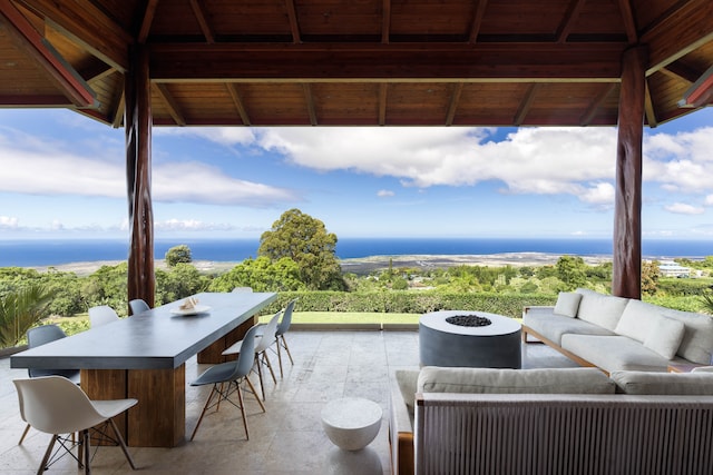 view of patio with a gazebo, an outdoor living space, and a water view