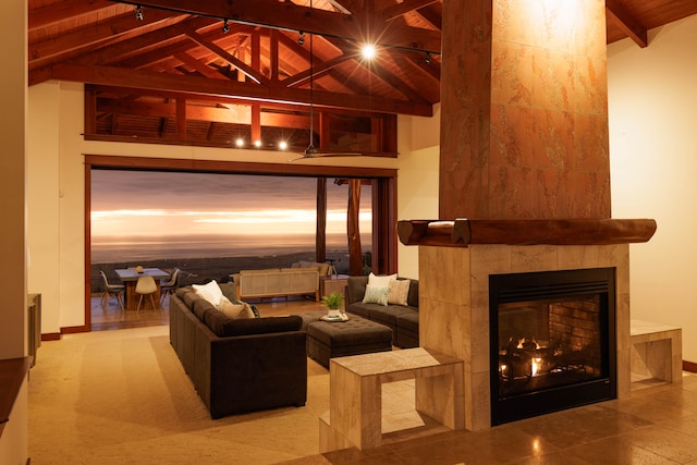 living room with a fireplace, high vaulted ceiling, and beamed ceiling