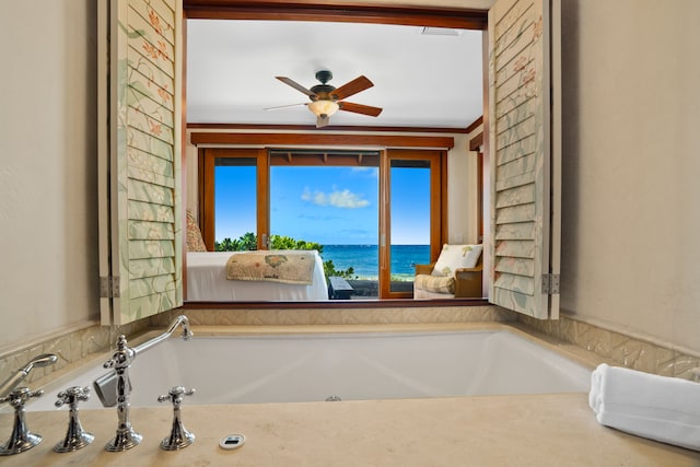 bathroom featuring ceiling fan, a water view, ornamental molding, and a bath