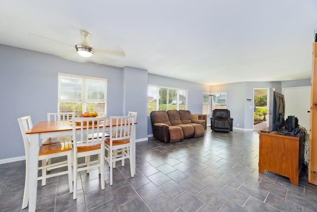 dining space featuring dark tile patterned floors and ceiling fan