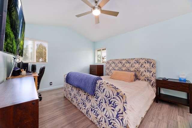 bedroom featuring ceiling fan, light hardwood / wood-style floors, and vaulted ceiling