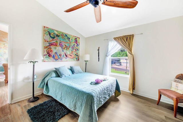 bedroom featuring light wood-style floors, vaulted ceiling, baseboards, and ceiling fan