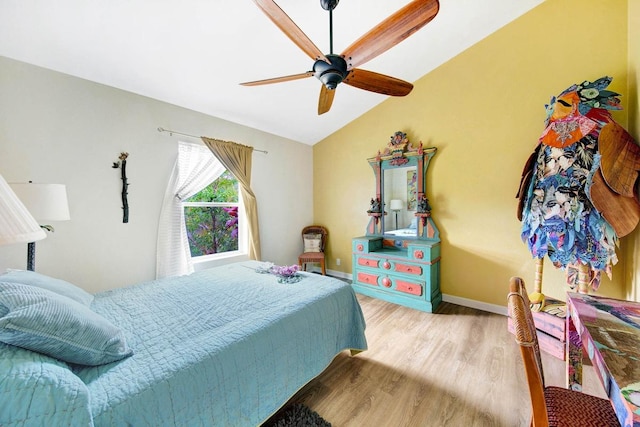 bedroom featuring lofted ceiling, light wood finished floors, a ceiling fan, and baseboards