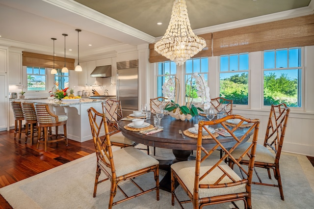 dining room with a notable chandelier, ornamental molding, and hardwood / wood-style flooring