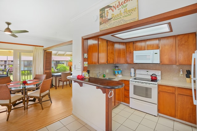 kitchen featuring ornamental molding, white appliances, backsplash, kitchen peninsula, and ceiling fan