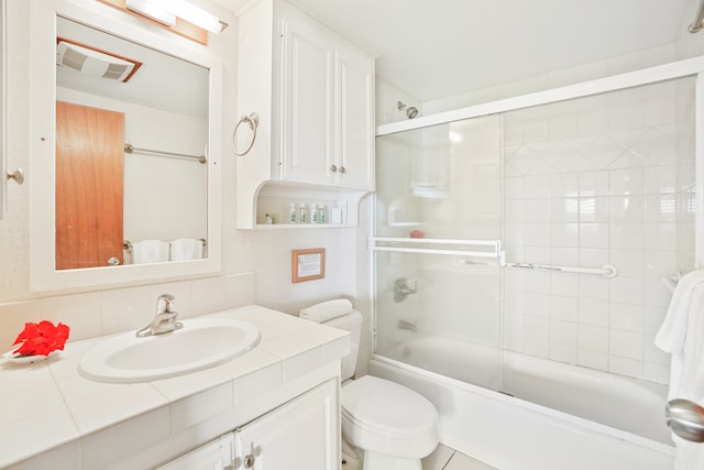 full bathroom with tile patterned flooring, toilet, combined bath / shower with glass door, and vanity