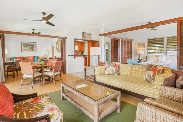 living room featuring crown molding, ceiling fan, and light hardwood / wood-style floors