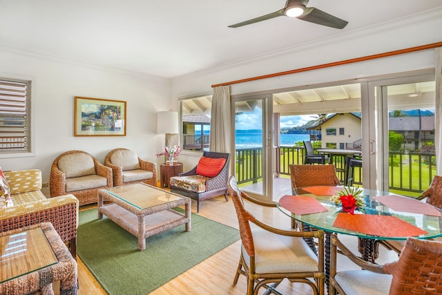 living room featuring a water view, ceiling fan, ornamental molding, and light hardwood / wood-style flooring