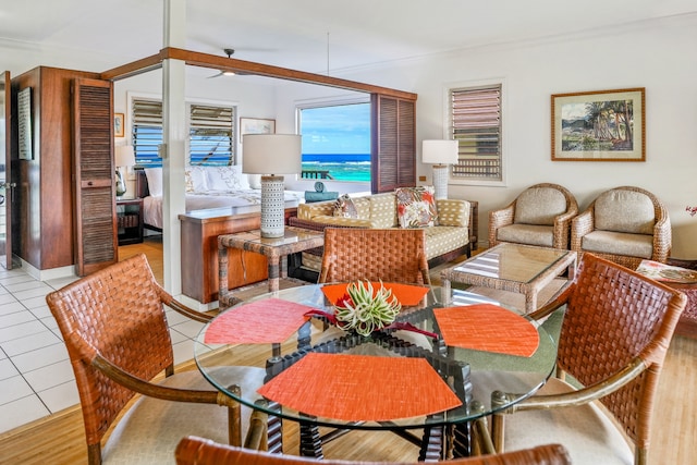 tiled dining area featuring a water view and crown molding