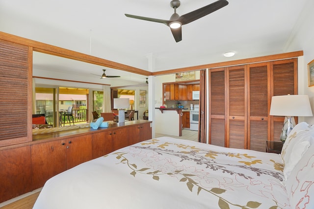 bedroom with crown molding, light hardwood / wood-style floors, ceiling fan, and a closet