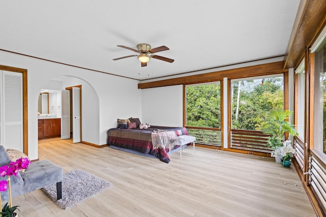 bedroom featuring ceiling fan, connected bathroom, and light hardwood / wood-style flooring