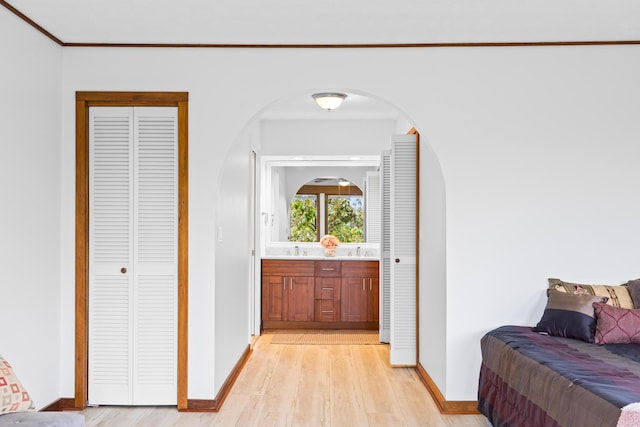 corridor featuring crown molding, sink, and light hardwood / wood-style floors