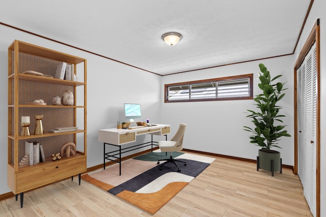 office featuring ornamental molding, a textured ceiling, and light wood-type flooring