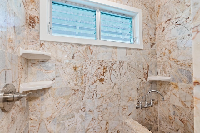 bathroom featuring a tile shower and a healthy amount of sunlight