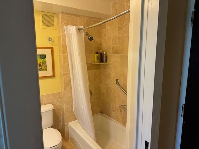 bathroom with tile walls, toilet, and shower / bath combination with curtain