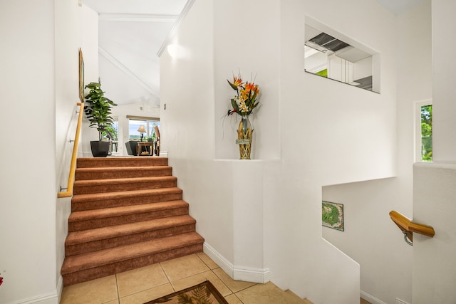 stairs with plenty of natural light and tile patterned floors