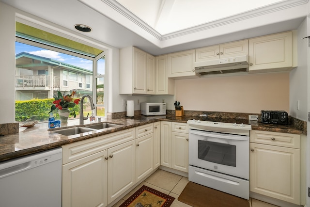 kitchen with white appliances, crown molding, sink, dark stone countertops, and light tile patterned flooring